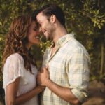 Loving couple standing by trees at olive farm