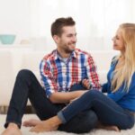 Loving couple sitting on floor in living room