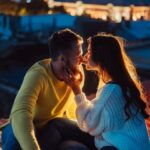 Loving couple is sitting on the roof of the house.