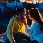 Loving couple is sitting on the roof of the house.