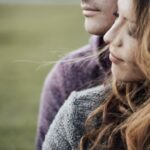 Young loving couple sitting on the grass