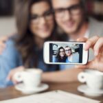 Loving couple taking selfie at cafe