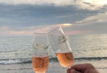 Ljubav s ukusom šampanjca couple clinking glasses of champagne on seashore