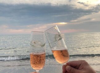 Ljubav s ukusom šampanjca couple clinking glasses of champagne on seashore
