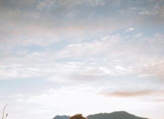 Zapleši sa mnom woman in white long sleeve shirt sitting on green grass field