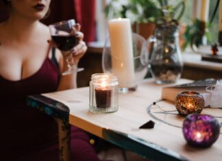 Tajanstvena žena unrecognizable soothsayer with glass of drink at table