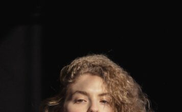 Seksualno ucenjena trendy young woman touching chin and looking at camera