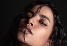 Ucenjena Striking portrait of a woman with wet hair and intense gaze, captured in a studio setting.