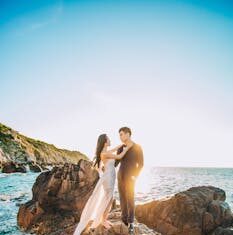 Ljubav na otoku🎁 A couple posing on rocky seaside for a wedding photoshoot in Vietnam under a clear sunny sky.